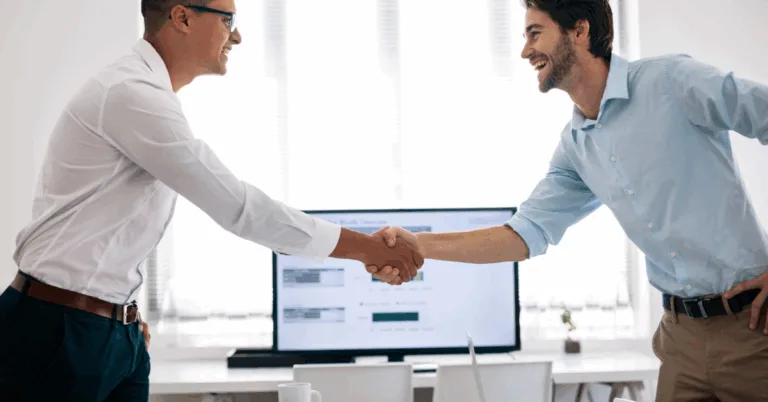 Men shaking hands infront of a screen